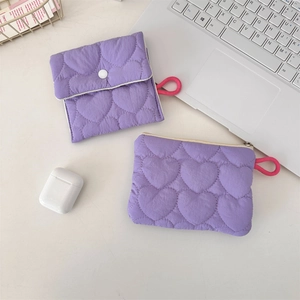 Close-up of two purple quilted heart storage pouches with snap and zipper closure