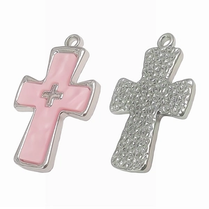 Detailed view of silver cross pendants with pink inlay and hammered metal texture