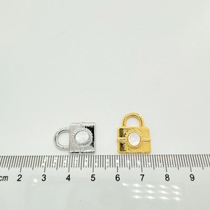 Detail view of gold and silver heart-shaped shell lock pendants with scale measurement