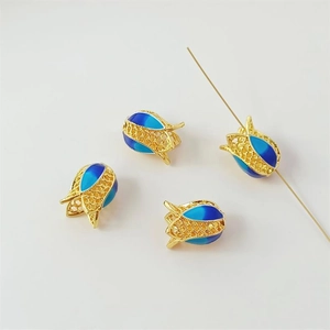 Macro detail of tulip flower bead with blue enamel and gold finish for jewelry making