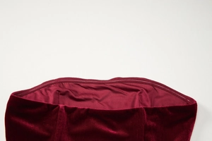 Detail of burgundy velvet dress neckline showing inner lining and fine stitching