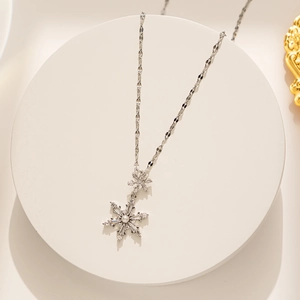 Macro detail of silver snowflake necklace with white pearl and sparkling zircons