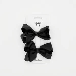 Set of two black ribbed ribbon bow hair clips for girls on a fashion display card
