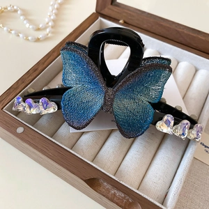 Détail de la pince à cheveux papillon en maille bleue et strass en forme de cœur