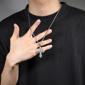 Gros plan d'un collier pendentif croix en zircon argenté avec chaîne torsadée sur homme