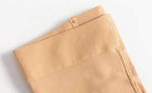 Close-up of elastic ribbed cuffs on skin-colored over-the-knee tights for women