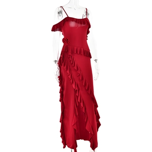 Detail of red backless slip dress with asymmetric ruffles and rose waist embellishment