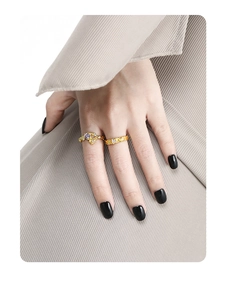 Detail of gold lava texture rings with purple stone on model with black nails
