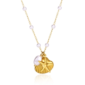 Detailed close-up of golden seashell and starfish pendant necklace with white pearls