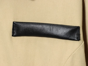Détail du tissu en toile kaki et garniture en cuir noir avec couture de qualité sur veste
