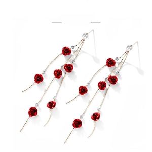 Close-up of red rose tassel earrings with rhinestone accents on long gold chains