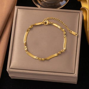 Elegant gold twisted snake chain bracelet in stainless steel on luxury jewelry box