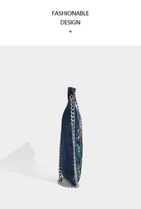 Detailed side view of denim crossbody bag featuring floral embroidery and silver chain strap