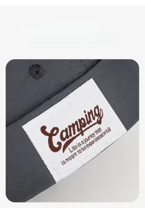 Detail of grey docker hat featuring an embroidered white label with Camping text