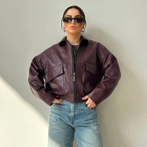 Dettaglio del bomber in pelle bordeaux con grandi tasche a patta e chiusura a zip