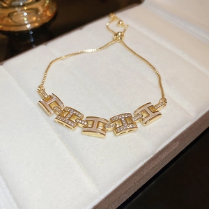 Détail du bracelet lettre H plaqué or avec zircons brillants et incrustation blanche