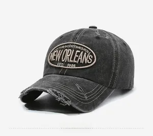Detail of vintage washed charcoal baseball cap with distressed brim and embroidery