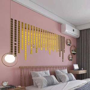 Self-adhesive gold square mirror tiles creating geometric wall art on a pink bedroom wall