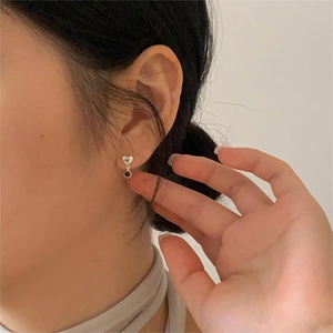 Close-up of minimalist 925 silver heart stud earring worn on ear with clean background