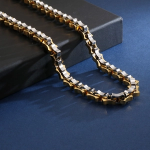 Detail of 18K gold plated geometric link chain for men draped over a premium gift box
