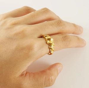 Detail of 18K gold-plated irregular spiral croissant ring on female finger