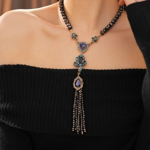 Détail d'un collier vintage serpent avec pierre violette et pampilles de perles noires