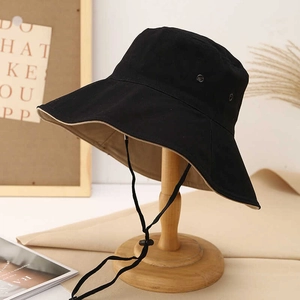 Outdoor sun protection bucket hat with wide brim and adjustable drawstring on wooden stand