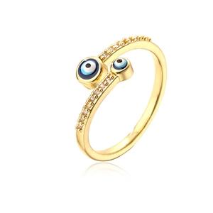 Close-up of 18K gold ring with enamel devil eye charms and sparkling zircon inlay
