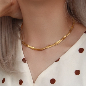 Primo piano di una collana a doppia catena piatta a serpente placcata in oro 18K sul collo