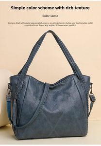 Detail of grey-blue soft leather handbag featuring woven handles and metal tassel charm