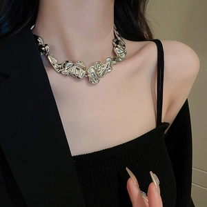 Close-up of a liquid metal irregular necklace on a model showing silver metallic texture