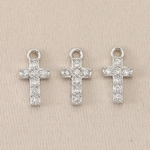 Detailed macro view of three vintage baroque cross pendants with sparkling gemstones