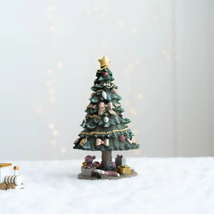 Détail d'un sapin de Noël en résine avec étoile dorée et boîtes cadeaux miniatures