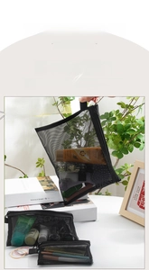 Three sizes of black mesh cosmetic bags organized for travel and makeup storage
