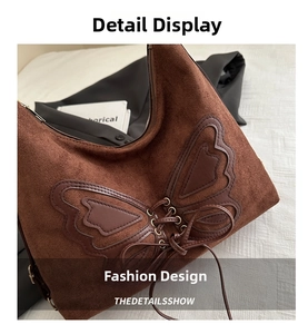 Close-up of brown suede hobo bag featuring butterfly leather appliqué and lace-up details