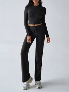 Slim-fit black long-sleeve crop top and drawstring wide-leg pants set shown on model
