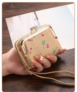 Detail of beige cherry pattern card holder wallet with gold clasp and wrist strap