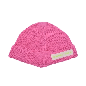 Detailaufnahme der pinkfarbenen Strickmütze mit Rollsaum und genähtem Stoffaufnäher