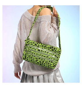Détail du sac bandoulière imprimé léopard vert néon avec plusieurs fermoirs en métal