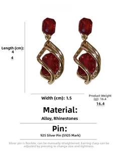 Detail view of vintage gold earrings with red rhinestones and 925 silver needles