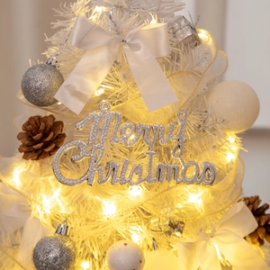 Detail of a 55cm mini white Christmas tree with silver balls, pinecones and warm fairy lights