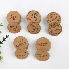 Detail of five round kraft paper gift tags with handmade and thank you print designs
