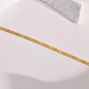 Minimalist gold titanium steel mariner link necklace on white stone decorative background