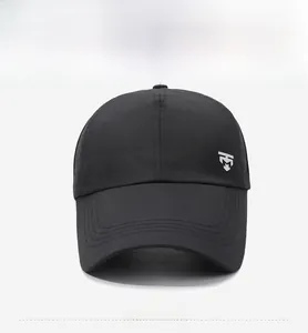 Detail view of the silver shield logo on a black summer baseball cap with fine texture
