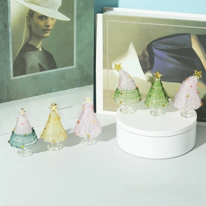 Handcrafted glass Christmas trees with colorful spiral textures and golden star toppers