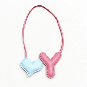 Dettaglio ciondolo borsa lettera Y rosa e cuore azzurro con bordi cuciti a mano