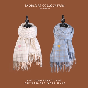 Detail of plaid scarves with heart embroidery and long tassels on high-quality fabric