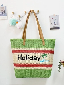 Detail of striped woven straw tote bag with Holiday embroidery and leather straps