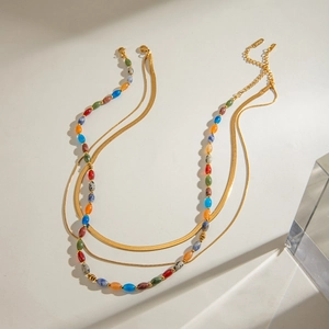 Detailed view of triple-layered golden snake chain necklace with colorful stone beads