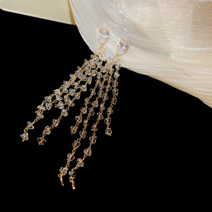 Detail of 18k gold-plated drop earrings with zircon tassels and crystal beads